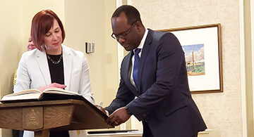 Kaliche Madu signs his appointment paper during the swearing in of the new Alberta Cabinet Ministers